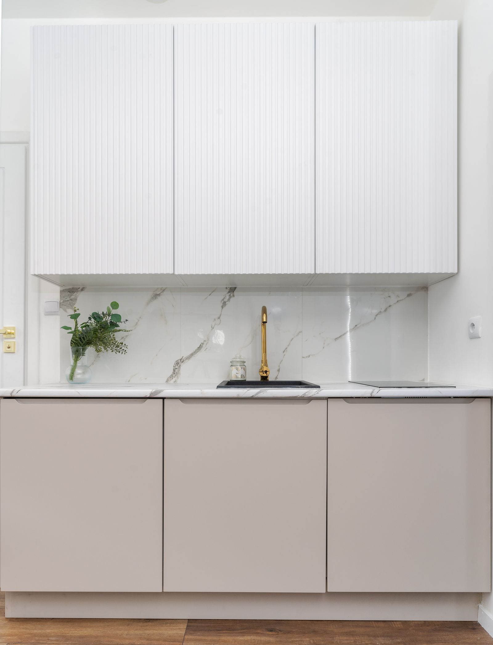 Minimalist custom kitchen with marble backsplash and brass fixtures