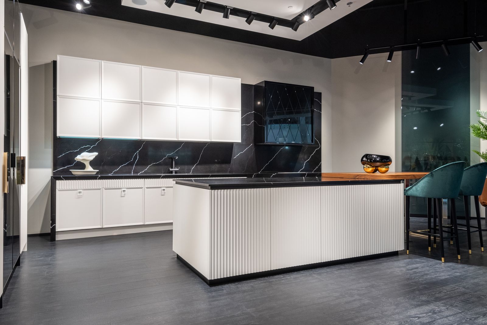 Custom kitchen with central island, white cabinetry and black countertops